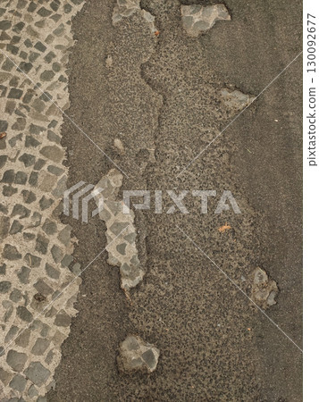 Damaged asphalt road revealing cobblestone in kokorin, czechia 130092677
