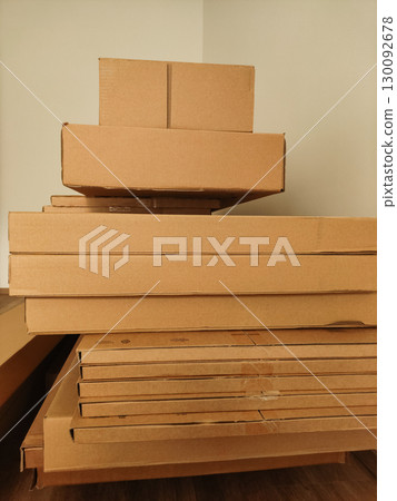 Stacked cardboard boxes in a room corner, storage and organization concept 130092678