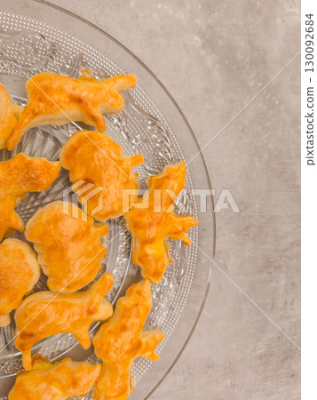 Halloween cookies shaped like animals resting on glass plate, copy space 130092684