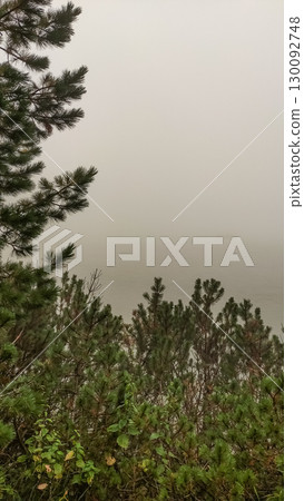 Fog covering strbske pleso lake in the high tatras mountains, slovakia 130092748