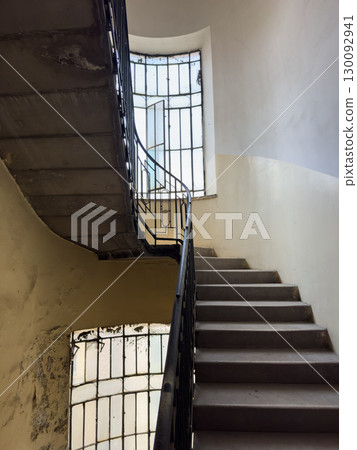 Vintage staircase with large window and metal railings showcasing industrial style Vintage staircase with large window and metal railings showcasing industrial style 130092941