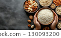Young child grasping ceramic bowl, displaying eid al fitr treats amid scattered nuts, seeds, traditional sweets copy space Uraza Bayram 130093200
