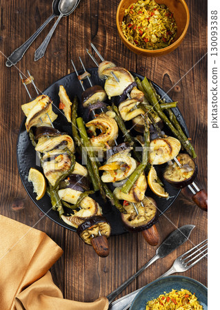 Delicious food on skewers, fish kebabs. 130093388