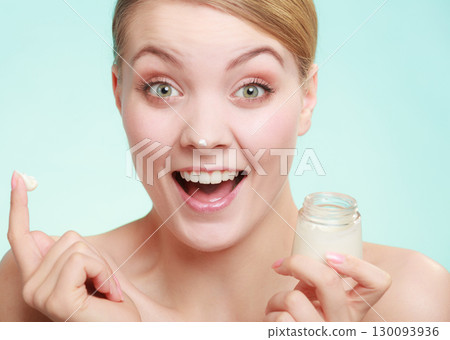 woman applying cream on her skin face. 130093936