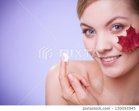 Skin care. Face of young woman girl with red maple leaf. Skin care. Face of young woman girl with red maple leaf. 130093945