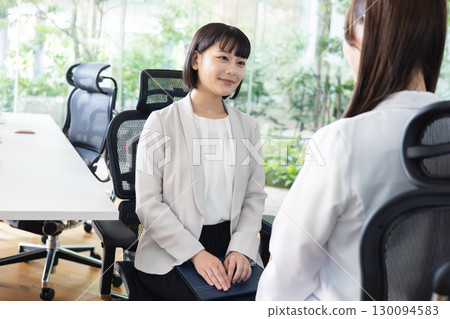 Businesswoman talking to an industrial physician 130094583