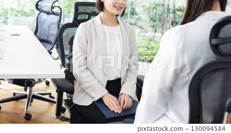 Businesswoman talking to an industrial physician 130094584