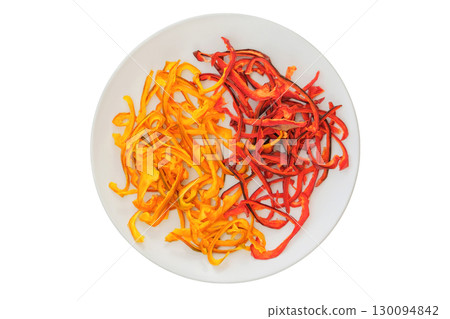 Dehydrated food. Ingredient for preparing a freeze-dried lunch. Dried sweet peppers on a ceramic plate isolated on a white background. Various dry of sweet peppers. 130094842