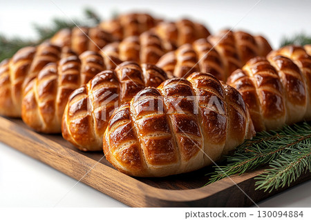Tasty baked buns. Christmas buns in the shape of a pine cone in on a wooden trading tray on a white background. 130094884