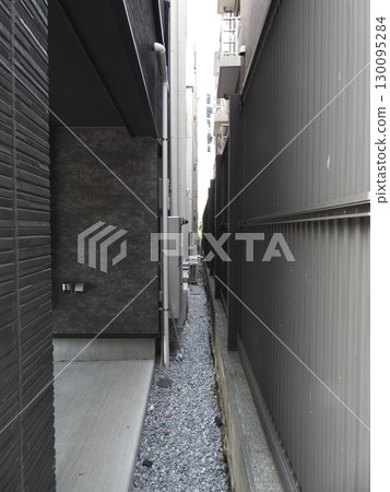 A narrow alleyway in the city, sandwiched between buildings and houses A narrow alleyway in the city, sandwiched between buildings and houses 130095284