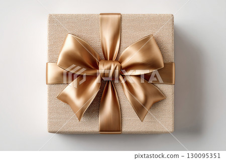 Gold decor. Luxury packaging. Elegant square gold box wrapped with a silver bow. Jewelry, birthdays and luxury branding. Top view. Gold decor. Luxury packaging. Elegant square gold box wrapped with a silver bow. Jewelry, birthdays and luxury branding. Top view. 130095351