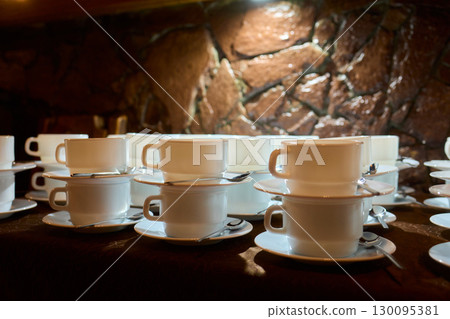 Neatly stacked white coffee cups for elegant events or catering, making a stylish presentation 130095381