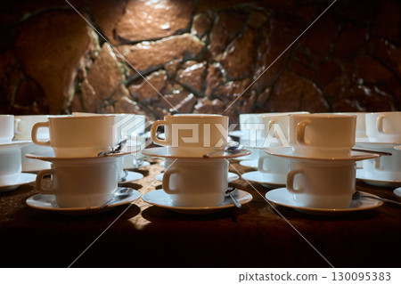 Neatly stacked white coffee cups for elegant events or catering, making a stylish presentation 130095383