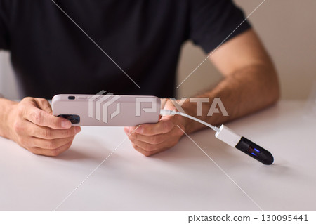 man using otg usb with her mobile phone to copy photos man using otg usb with her mobile phone to copy photos 130095441