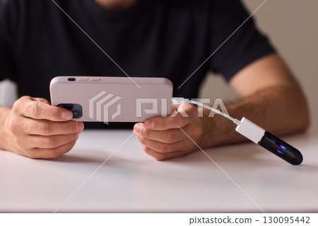 man using otg usb with her mobile phone to copy photos 130095442