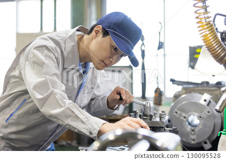 一名男工人在工廠操作機器 一名男工人在工廠操作機器 130095528