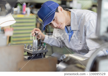 Male worker operating a machine in a factory Male worker operating a machine in a factory 130095529