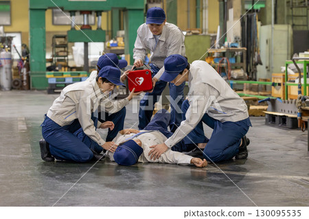 一群人使用 AED 幫助一名在工廠昏倒的工人 130095535