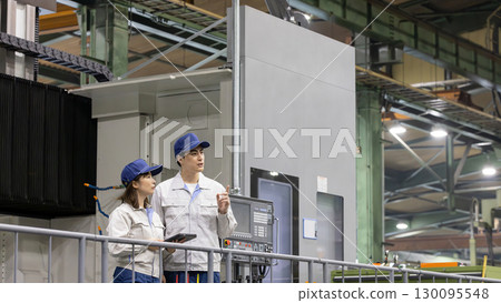 Male and female workers working in a factory Male and female workers working in a factory 130095548