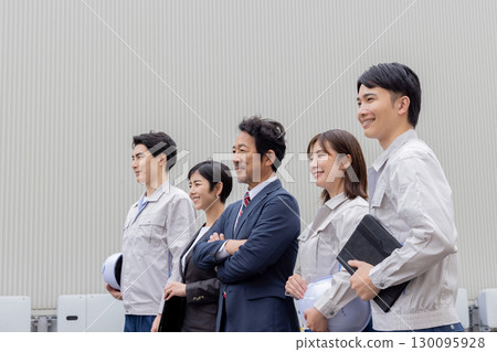 A group of company employees lined up in front of a building A group of company employees lined up in front of a building 130095928