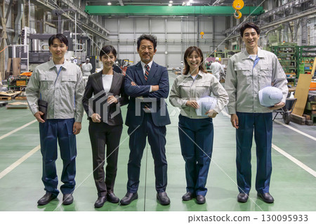Group of workers standing side by side in a factory 130095933