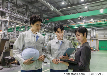 A female business person and a male worker inspecting a factory 130095939