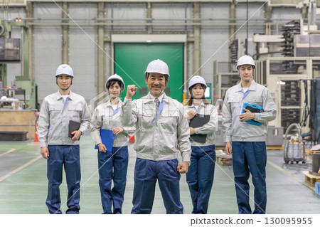 Workers pumping their fists in a factory 130095955