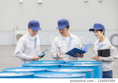 A group of workers managing the inventory of drums 130095984