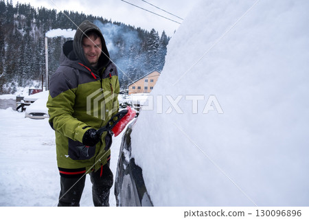 Person Clearing Snow from Car in Winter Landscape Person Clearing Snow from Car in Winter Landscape 130096896