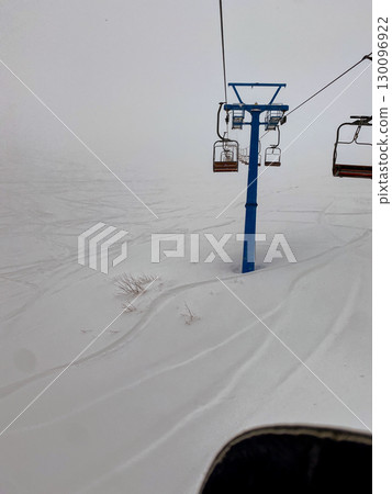 Foggy Ski Lift with Empty Red Chairs Foggy Ski Lift with Empty Red Chairs 130096922