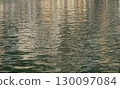 Water textures with light and ripples. Moving water in the harbour give beautiful shimmery textures and surfaces for backgrounds with space for copy 130097084
