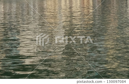 Water textures with light and ripples. Moving water in the harbour give beautiful shimmery textures and surfaces for backgrounds with space for copy 130097084