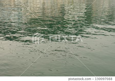 Water textures with light and ripples. Moving water in the harbour give beautiful shimmery textures and surfaces for backgrounds with space for copy 130097088