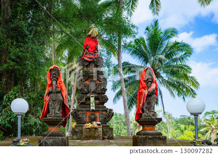 Statues of the Brahma and gods wrapped in red cloth in Balinese Pande temple. Traditional stone carvings, culture, religion and ritual offerings on tropical Bali island. Travel on vacation in Asia. Statues of the Brahma and gods wrapped in red cloth in Balinese Pande temple. Traditional stone carvings, culture, religion and ritual offerings on tropical Bali island. Travel on vacation in Asia. 130097282