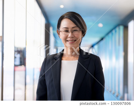 Smiling business woman standing 130097806