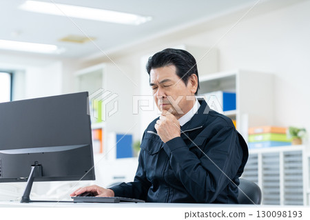 Senior engineer working in the office 130098193