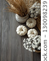 Minimalist fall white and sage pumpkins arranged on a grey wooden floor 130098239