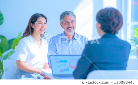 A business woman who sells to a middle-aged couple 130098443