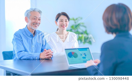 A business woman who sells to a middle-aged couple 130098448