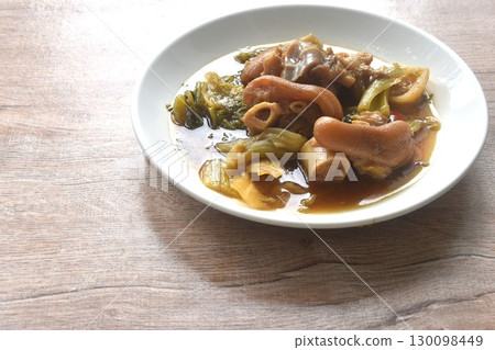 boiled braised salty pork leg and slice pickled cabbage in Chinese herb brown soup on plate 130098449