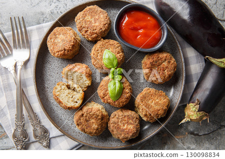 Homemade vegetarian fried eggplant balls served with tomato sauce close-up in a plate. Horizontal top view Homemade vegetarian fried eggplant balls served with tomato sauce close-up in a plate. Horizontal top view 130098834