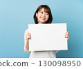 A smiling woman holding a blank white board 130098950