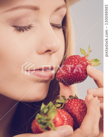 Young woman with fresh strawberry 130098985