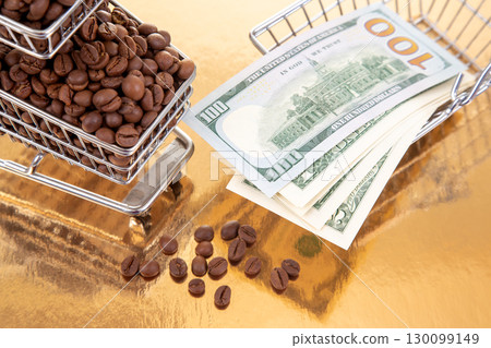 $100 bills and a cart of coffee beans on a golden surface create a visual of wealth and commerce $100 bills and a cart of coffee beans on a golden surface create a visual of wealth and commerce 130099149