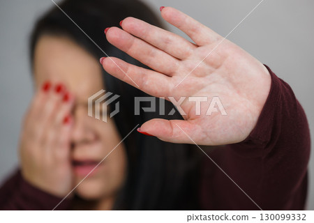 Scared woman with stop hand gesture 130099332