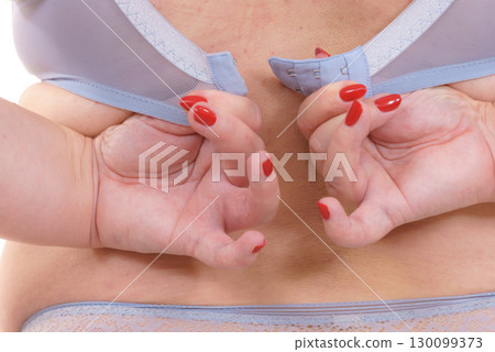 Woman back view putting on her bra lingerie. 130099373