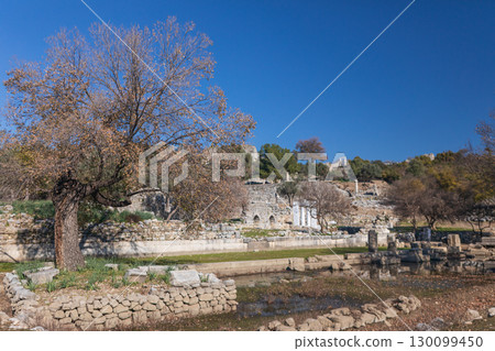 View of ancient Greek city Kaunos in Caria or Caunus in Roman period in Anatolia. Famous historical and archeological site. Popular place for family travel on summer vacation. Dalyan, Mugla Turkey View of ancient Greek city Kaunos in Caria or Caunus in Roman period in Anatolia. Famous historical and archeological site. Popular place for family travel on summer vacation. Dalyan, Mugla Turkey 130099450