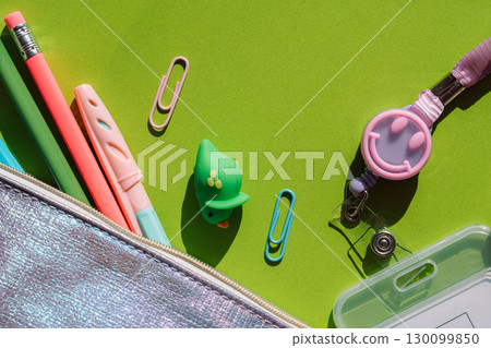 School stationery and colorful slinky toy on green background School stationery and colorful slinky toy on green background 130099850