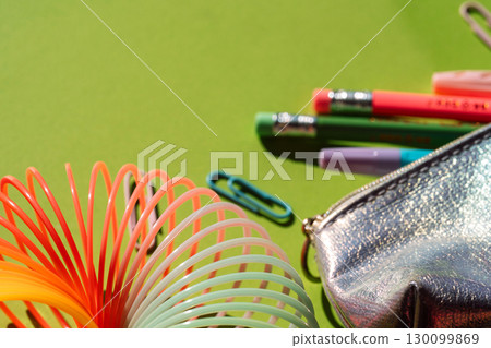 Close-up of metallic pencil case and rainbow slinky with stationery Close-up of metallic pencil case and rainbow slinky with stationery 130099869