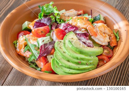 Fresh prawn avocado salad cherry tomatoes wooden table citrus dressing 130100165